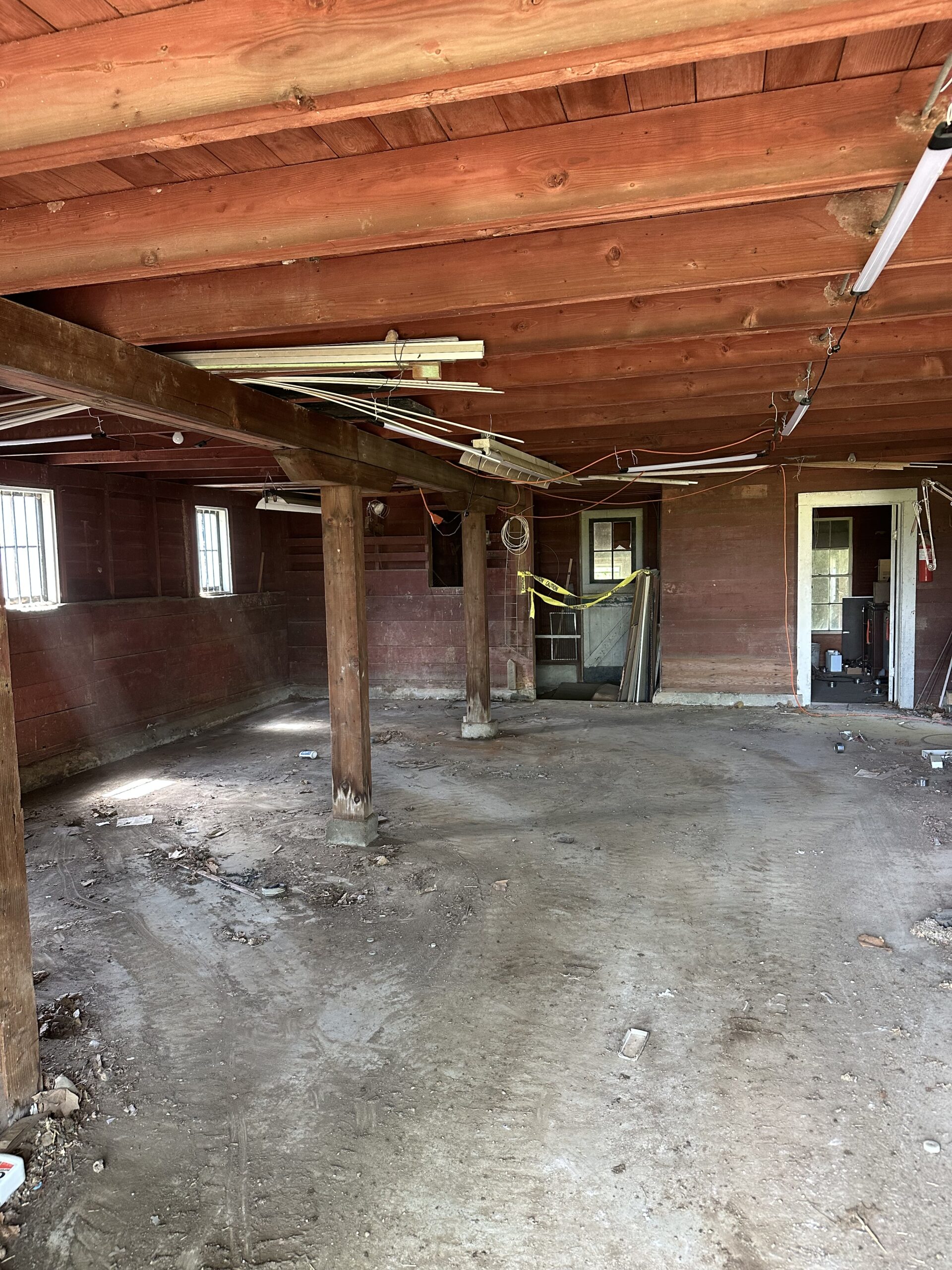 A clean wooden garage with tidy floor, exposed beams, and organized space after a professional garage cleanout service.